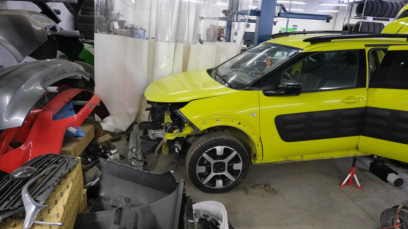 Żółty Citroen w naprawie powypadkowej na stanowisku w hali blacharskiej Bryksacar