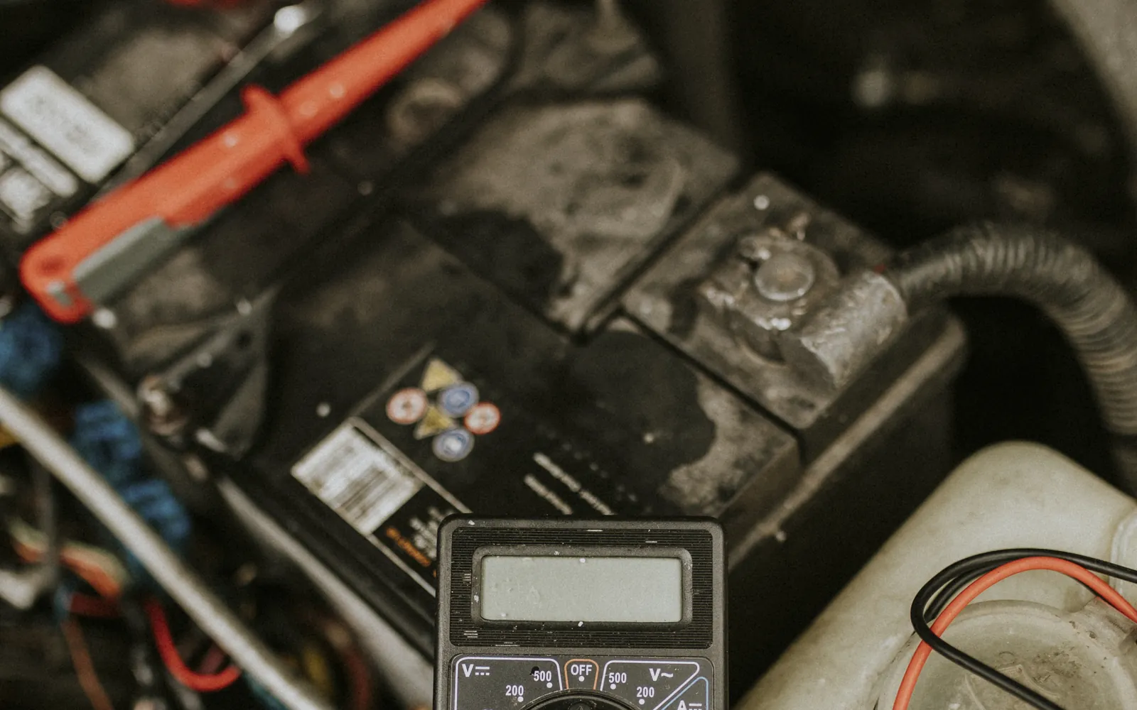 Mechanik trzyma tester diagnostyczny nad komorą silnika