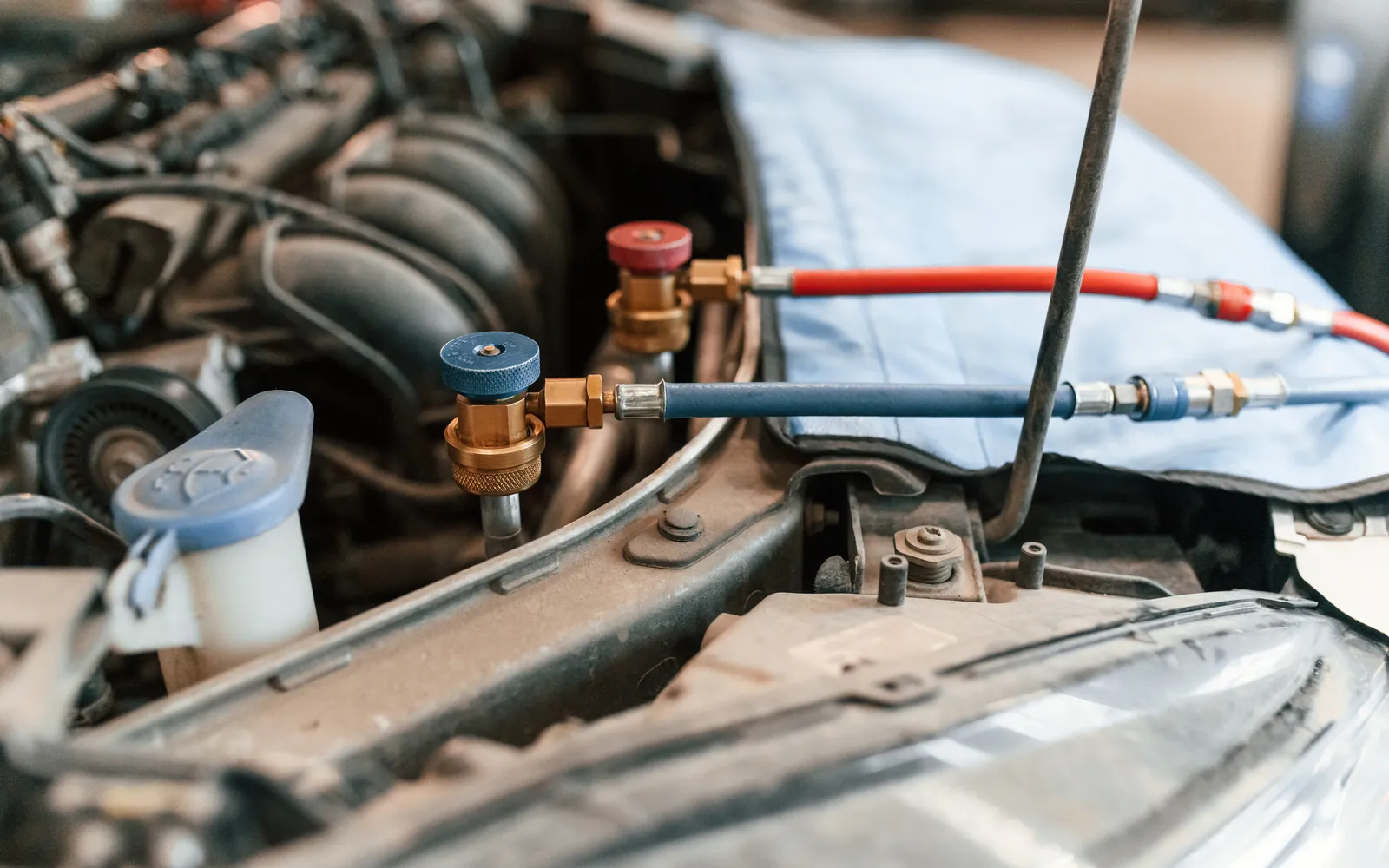 Mechanik sprawdza układ klimatyzacji podłączonym zestawem manometrów