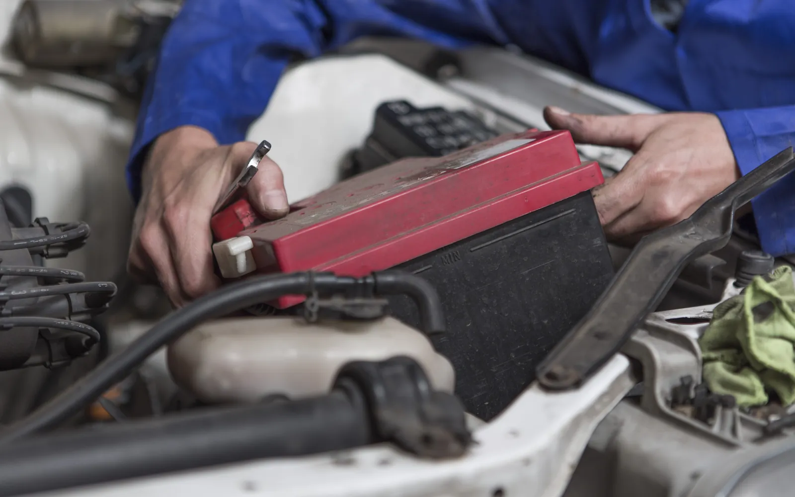 Mechanik trzyma tester diagnostyczny nad komorą silnika