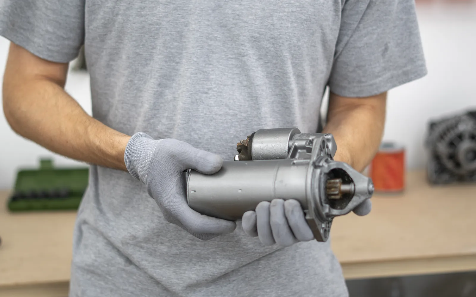 Mechanik trzyma tester diagnostyczny nad komorą silnika